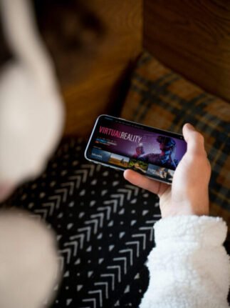 adolescente-sentado-em-sua-cama-assistindo-a-um-filme-em-seu-smartphone